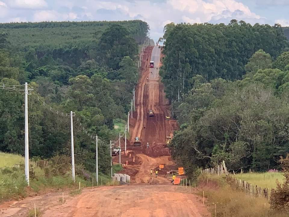 Aqui há uma foto de uma obra rodoviária onde a equipe está trabalhando na parte de terraplenagem da estrada, em preparo para a pavimentação.