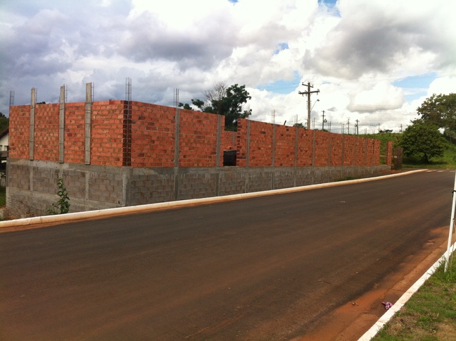 Execução de enchimento de concreto dos pilares de uma construção comercial.